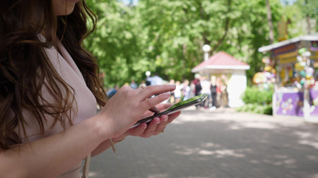 phone and woman in park for typing social mediaの写真素材