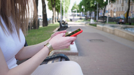 phone and woman in park for typing social mediaの写真素材