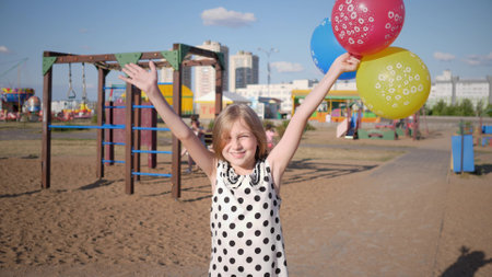 Beautiful little girl portrait in summer city parkの写真素材