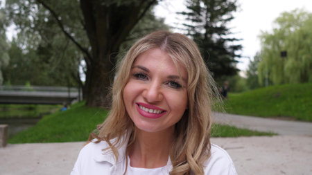 Beautiful caucasian blonde middle-aged woman portrait in the parkの写真素材