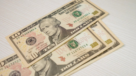 A detailed closeup view of several US Twenty Dollar Bills resting on a White Background