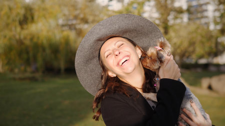 A Joyful Woman Enjoying a Heartwarming Embrace with Her Dog in Beautiful Nature Scenesの写真素材