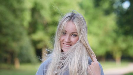 A Young Woman with a Radiant Smile, Flowing Hair, and Joyful Expression, Enjoying Natures Beautyの写真素材