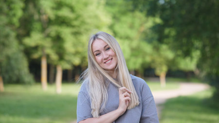 A Happy Young Woman is Joyfully Enjoying the Beauty of Nature in a Beautiful Parkの写真素材
