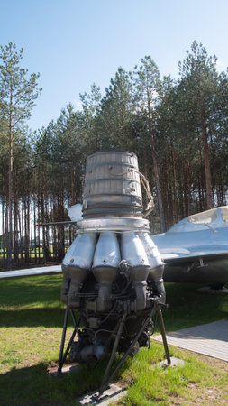 Vintage Soviet Rocket Engine Displayed in an Outdoor Exhibition Against a Backdrop of Tall Pine...