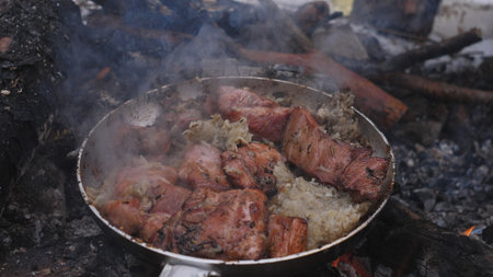 Sizzling Meat and Vegetables Cook Over Open Flames in a Rustic Outdoor Setting, Capturing the Essence of Traditional Culinary Techniquesの写真素材