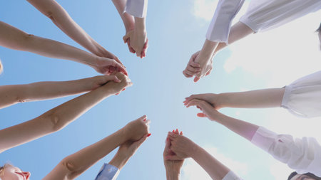 Various hands united together, set against a vibrant blue sky filled with hope and possibility