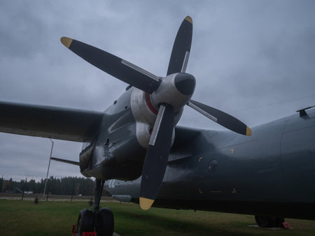 side profile cargo aircraft propeller and spinner with landing gear visible, cloudy sky and grounded