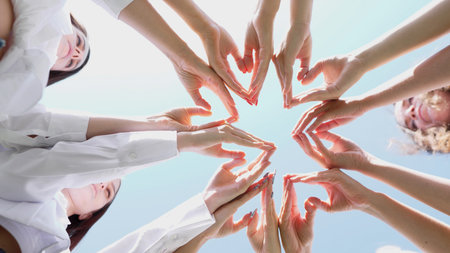 Two Hands Forming a Heart Shape Beautifully Against a Bright, Clear Sky Above Us