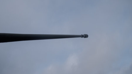 industrial gun against cloudy sky, moody shot of weathered tank barrel with cloudy atmospheric backdropの写真素材
