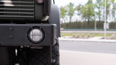 Military Vehicle on Display Showing Details of Front Light and Rugged Design in an Outdoor Setting...