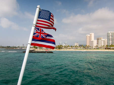 American and Hawaiian Flags off the back of a boat looking towards Waikikiの写真素材