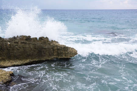 Surf crashing and splashing agains rocks on the shore