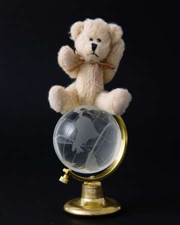 Teddy bear on top of the world isolated on a black backgroundの写真素材