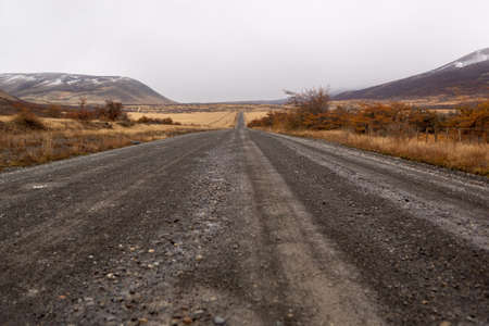 Dirt road vanishing into the distance down a hillの写真素材