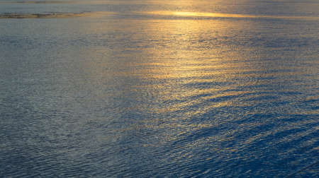 Water waves and sunlight reflecting in the oceanの写真素材