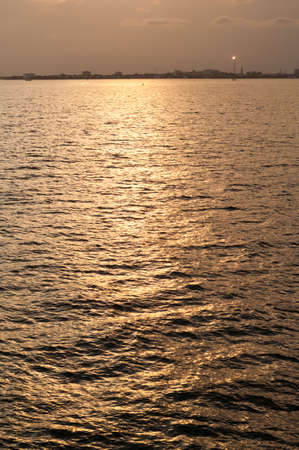 Golden water reflections suitable as a background or texture. available in both portrait and landscape orientationの写真素材