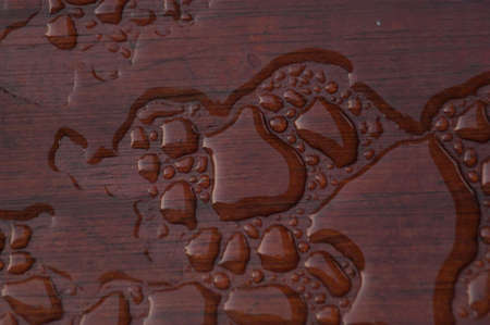 Pooled water on finished deck with woodgrain. Excellent background for illustrating construction or resilience.の写真素材