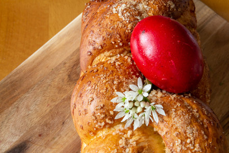 Easter cake with a red egg and flowers on a wooden board