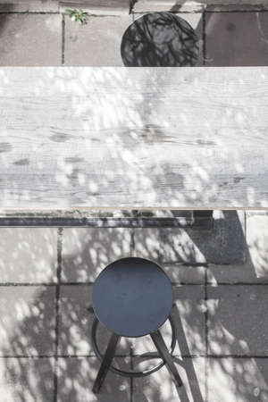 Bar stool, wooden table on a street pavementの写真素材