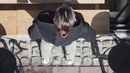 A girl ordering coffee in the street bar window waiting for coffeeの写真素材