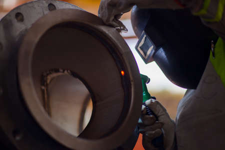 Man works on metal welding steel using electric welding machine to weld.の写真素材