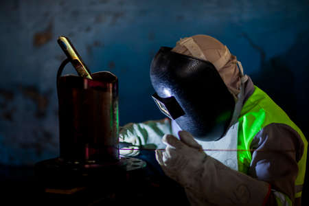 Man works on metal welding steel using electric welding machine to weld.の写真素材