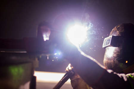 Man works on metal welding steel using electric welding machine to weld.の写真素材