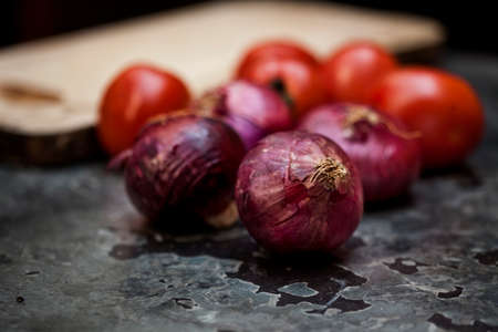 Tomatoes and onions on a kitchen cooking boards. Food background. high quality photoの写真素材