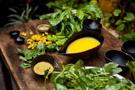 Amazonian cuisine. Green ingredients, manioc soup on a wooden table set. high quality photoの写真素材