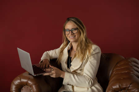 Young woman working at home with laptop and papers on desk and headphones. Home office concept. Gray notebook for working. high quality photoの写真素材