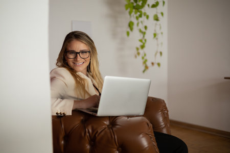 Young woman working at home with laptop and papers on desk and headphones. Home office concept. Gray notebook for working. high quality photoの写真素材