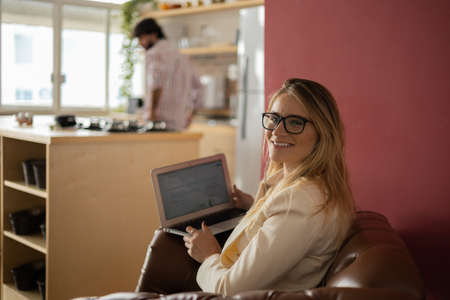 Young woman working at home with laptop and papers on desk and headphones. Home office concept. Gray notebook for working. high quality photoの写真素材