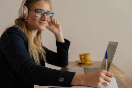 Young woman working at home with laptop and papers on desk in her bedroom. Home office concept. Gray notebook for working. high quality photoの写真素材