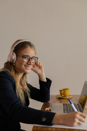 Young woman working at home with laptop and papers on desk in her bedroom. Home office concept. Gray notebook for working. high quality photoの写真素材