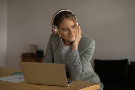 Young woman working at home with laptop and papers on desk in her bedroom. Home office concept. Gray notebook for working. high quality photoの写真素材
