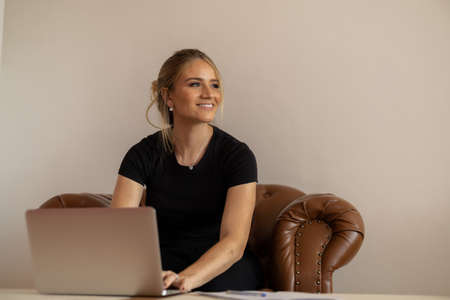 Young woman working at home from her bedroom with laptop on her bed. Woman lying down. Home office concept. Gray notebook for working. Cozy and comfortable. Home office concept. high quality photoの写真素材