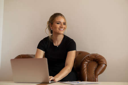 Young woman working at home from her bedroom with laptop on her bed. Woman lying down. Home office concept. Gray notebook for working. Cozy and comfortable. Home office concept. high quality photoの写真素材