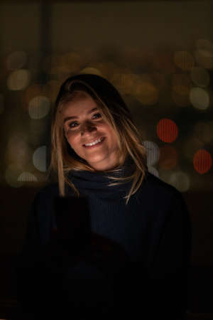 Young woman using a smartphone at day time with a green park in the background. High quality photo. Mobile phone, technology, urban concept. high quality photoの写真素材