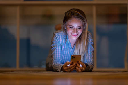 Young woman using a smartphone at day time with a green park in the background. High quality photo. Mobile phone, technology, urban concept. high quality photoの写真素材