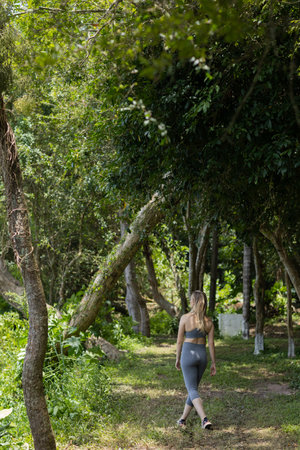 Happy young woman exercising at a park on a beautiful sunny day. Woman working out. Green and nature background. high quality photoの写真素材