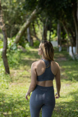 Happy young woman exercising at a park on a beautiful sunny day. Woman working out. Green and nature background. high quality photoの写真素材