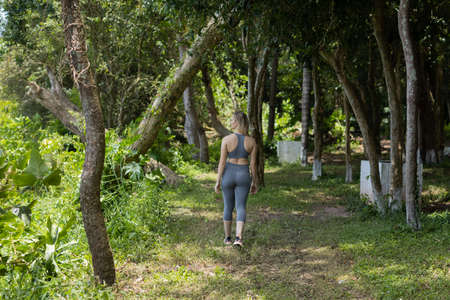 Happy young woman exercising at a park on a beautiful sunny day. Woman working out. Green and nature background. high quality photoの写真素材