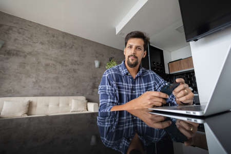Young white man working at home with laptop on desk. Home office concept. Gray notebook for working. high quality photoの写真素材
