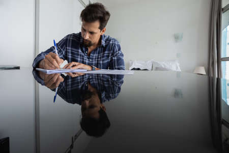 Young white man working at home with laptop on desk. Home office concept. Gray notebook for working. high quality photoの写真素材