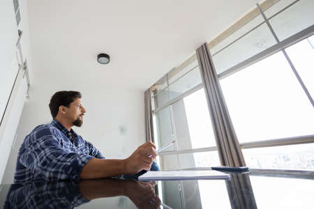 Young white man working at home with laptop on desk. Home office concept. Gray notebook for working. high quality photoの写真素材