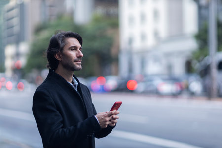 View of young man with smartphone at daytime with city view landscape in the background. High quality photo.の写真素材