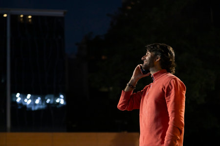 View of young man using a smartphone at night time with city view landscape in the background. High quality photo. View of young man using a smartphone at night time with city view landscape in the background. High quality photo.の写真素材