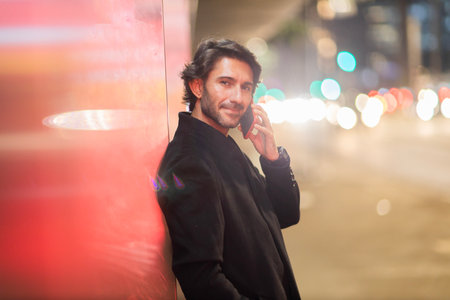 View of young man using a smartphone at night time with city view landscape in the background. High quality photo. View of young man using a smartphone at night time with city view landscape in the background. High quality photo.の写真素材