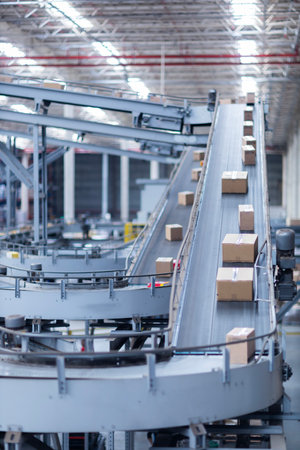 View of modern conveyor belts transporting boxes in a large warehouse ready for delivery